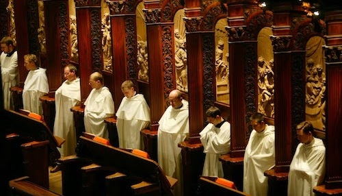 A group of priests in white robes standing in a church.