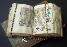 An open book with a rosary on it.