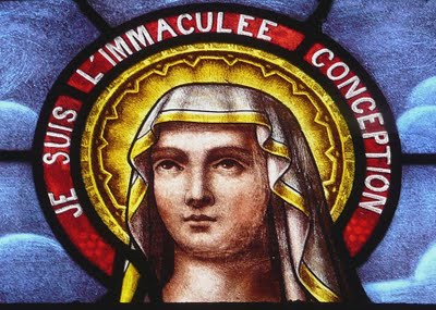 A stained glass window depicting the image of st immaculate conception.