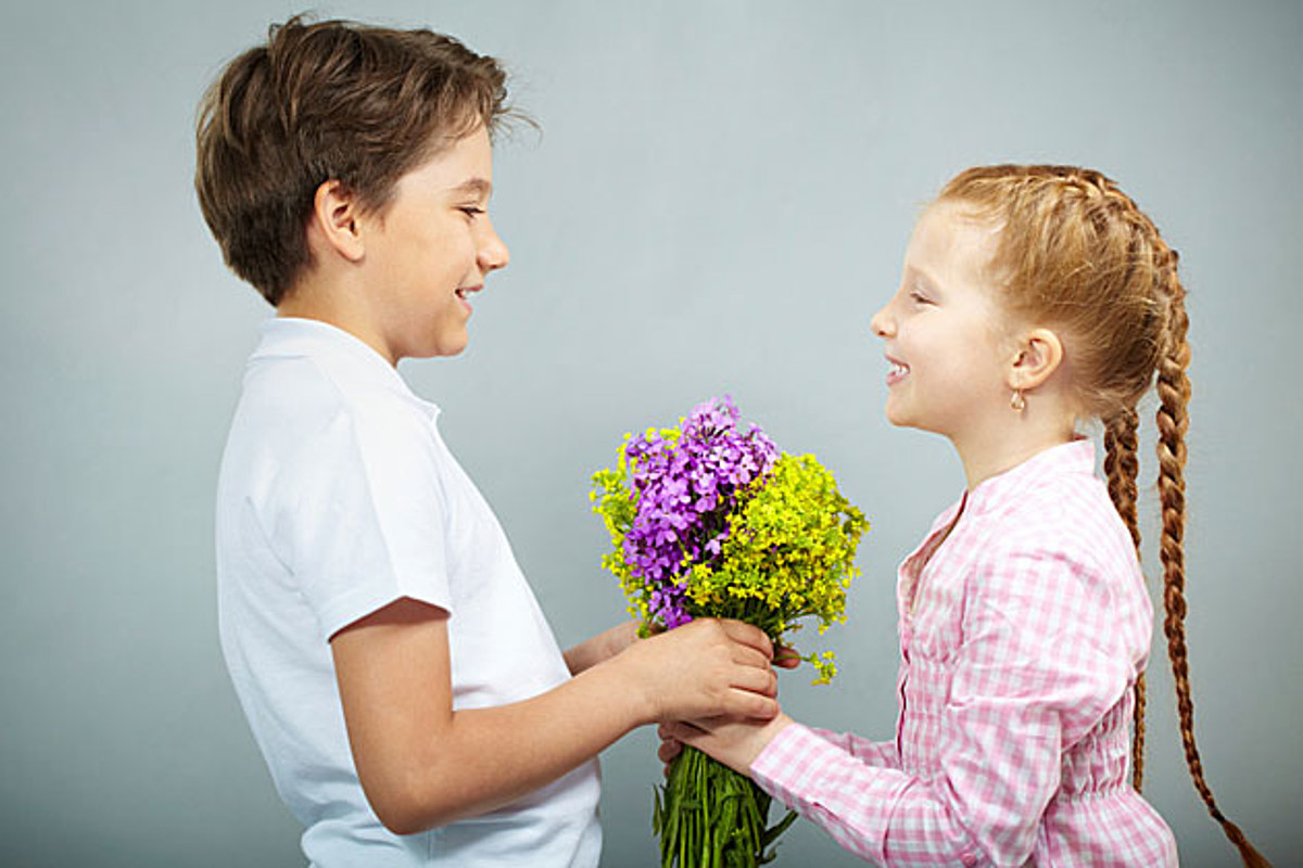 A boy and girl holding a bouquet of flowers.