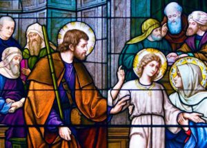 A stained glass window showing jesus and his disciples.