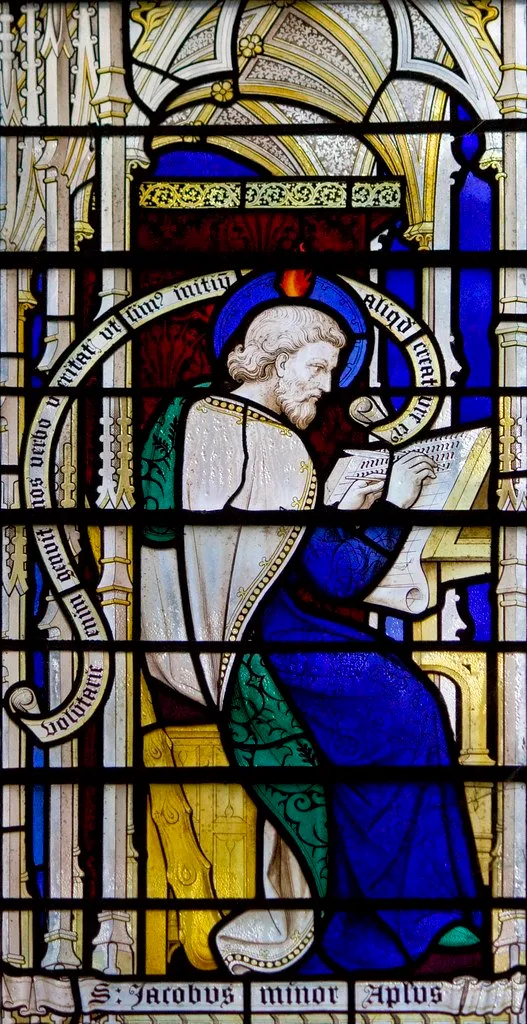 A stained glass window depicting a man reading a book.